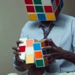 Seseorang berkepala rubik sedang memutar kepala rubik orang lain menggambarkan bagaimana kebebasan berpikir dan tafsir agama sering dikendalikan oleh tangan tangan manusia