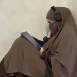 Seorang gadis berjilbab membaca buku sambil mengenakan headphone melambangkan pencarian makna dan refleksi dalam sejarah jilbab