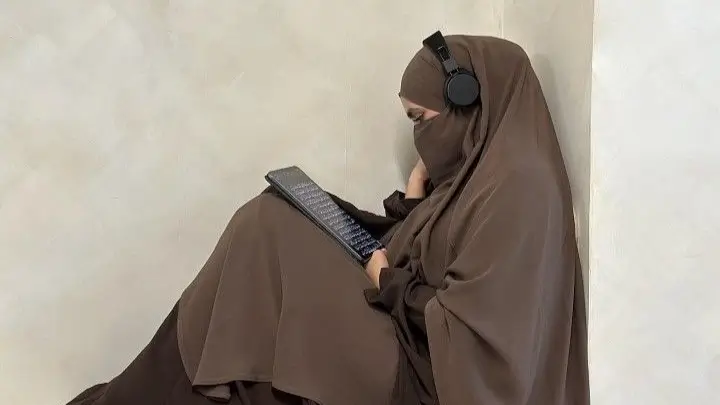 Jejak Panjang Dalam Sejarah Jilbab  Bitchology Seorang gadis berjilbab membaca buku sambil mengenakan headphone melambangkan pencarian makna dan refleksi dalam sejarah jilbab