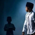 Seorang anak laki laki mengenakan peci hitam dengan ekspresi tenang menggambarkan simbol budaya dan nasionalisme Indonesia