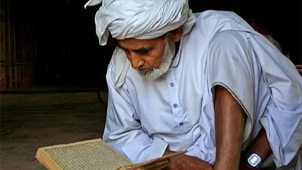 perbedaan ulama dalam Islam  Bitchology Seorang ulama tua berbaju putih tengah mempelajari Al Quran di hadapan murid muridnya sebagai simbol kebijaksanaan dan kedalaman ilmu Islam